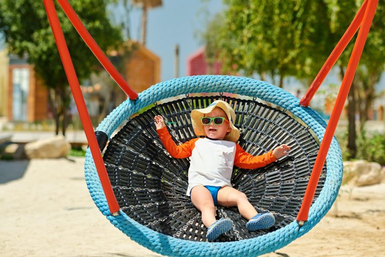 Toddler child swinging on beach